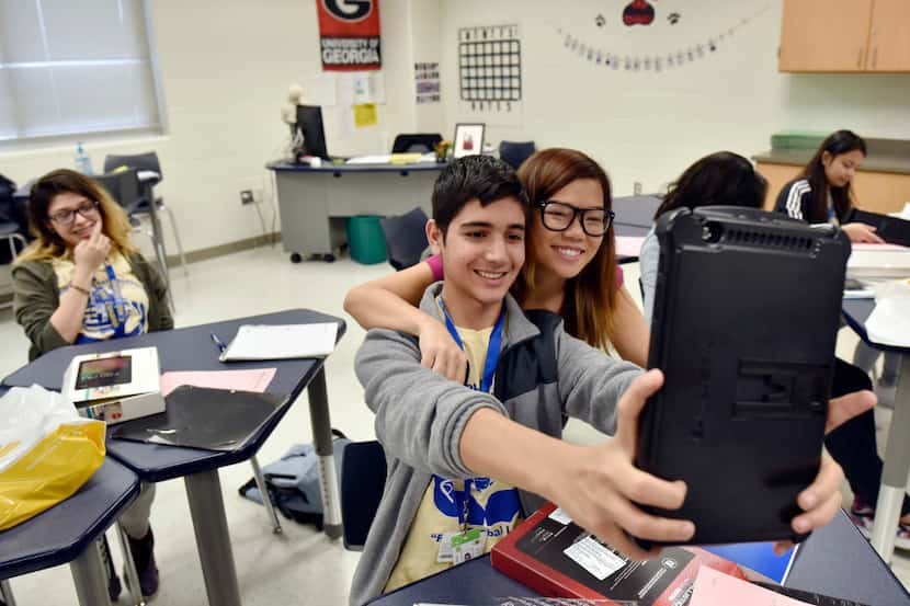 Student Mohammad Faroz takes a selfie with his new tablet of him and his math teacher Thuy...