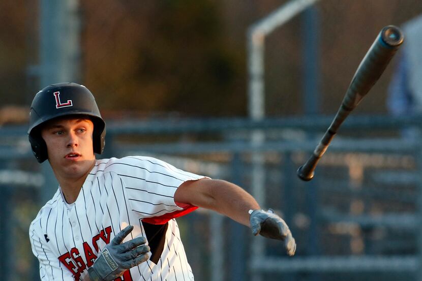 Mansfield Legacy catcher Nate Rombach (19) puts a spin on the bat as he sends it hurling...