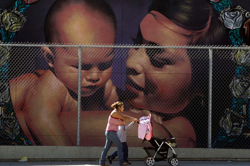A mother walks with her children to the MacArthur Park Primary Center School in Los Angeles...