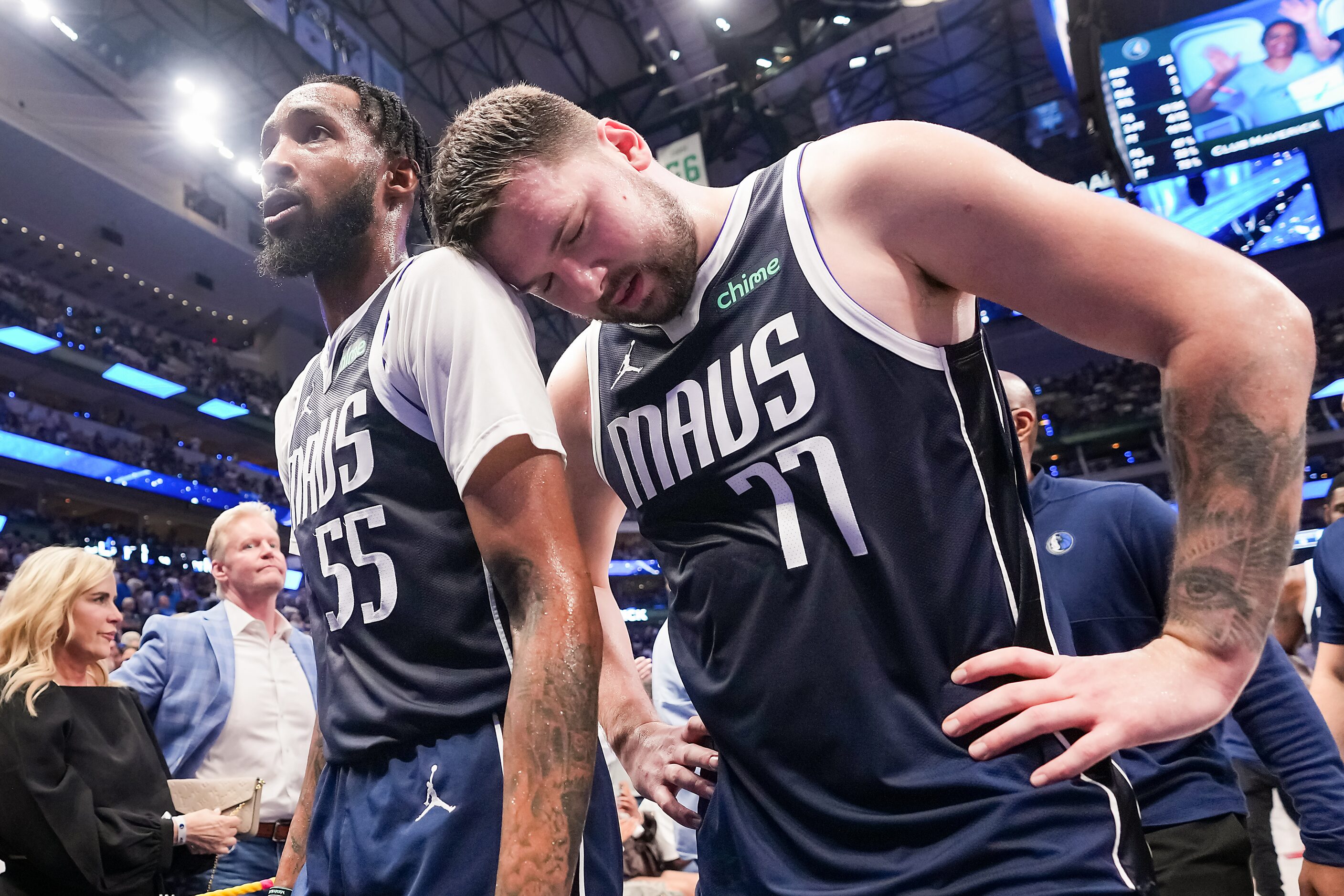 Dallas Mavericks guard Luka Doncic (77) leans on the shoulder of forward Derrick Jones Jr....