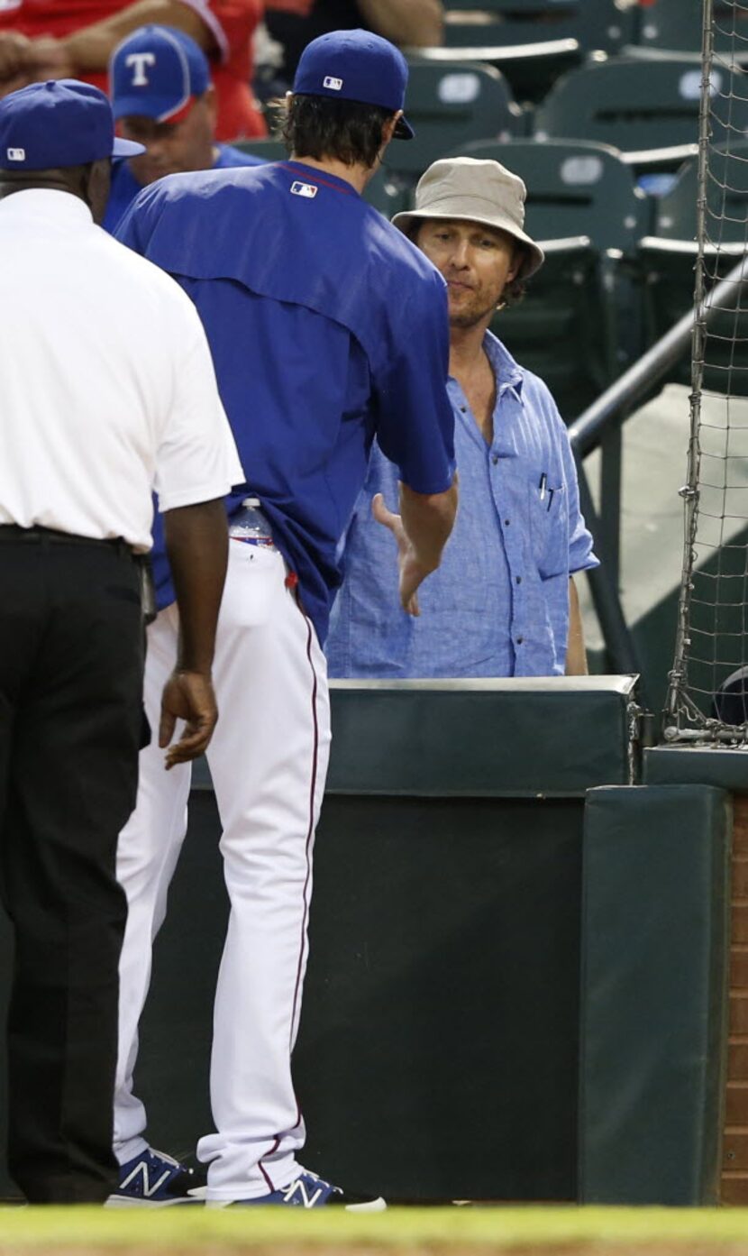 Texas Rangers starting pitcher Cole Hamels (35) talks to actor Matthew McConaughey between...