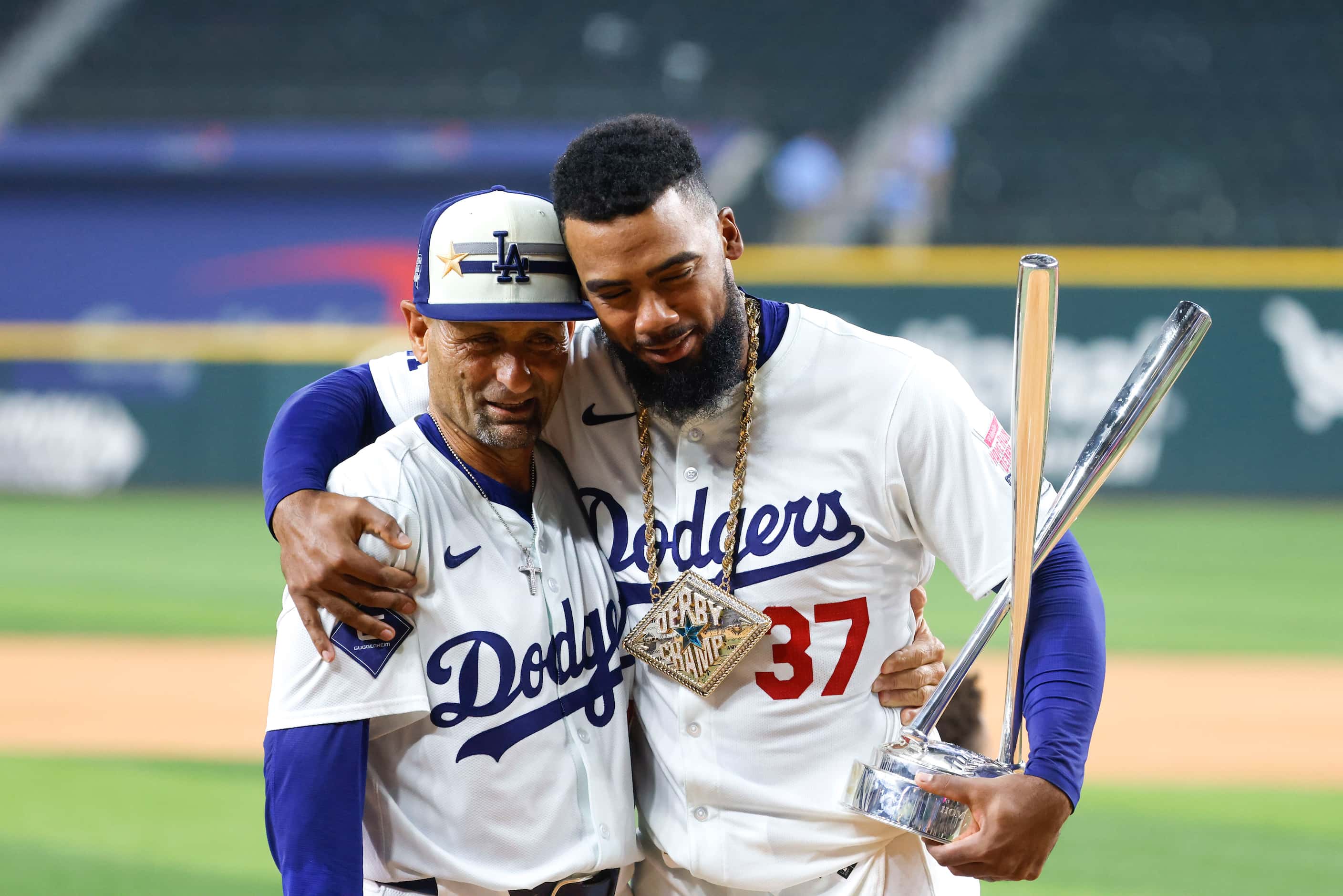 National League's Teoscar Hernández, of the Los Angeles Dodgers (left), hugs coach Dino Ebel...