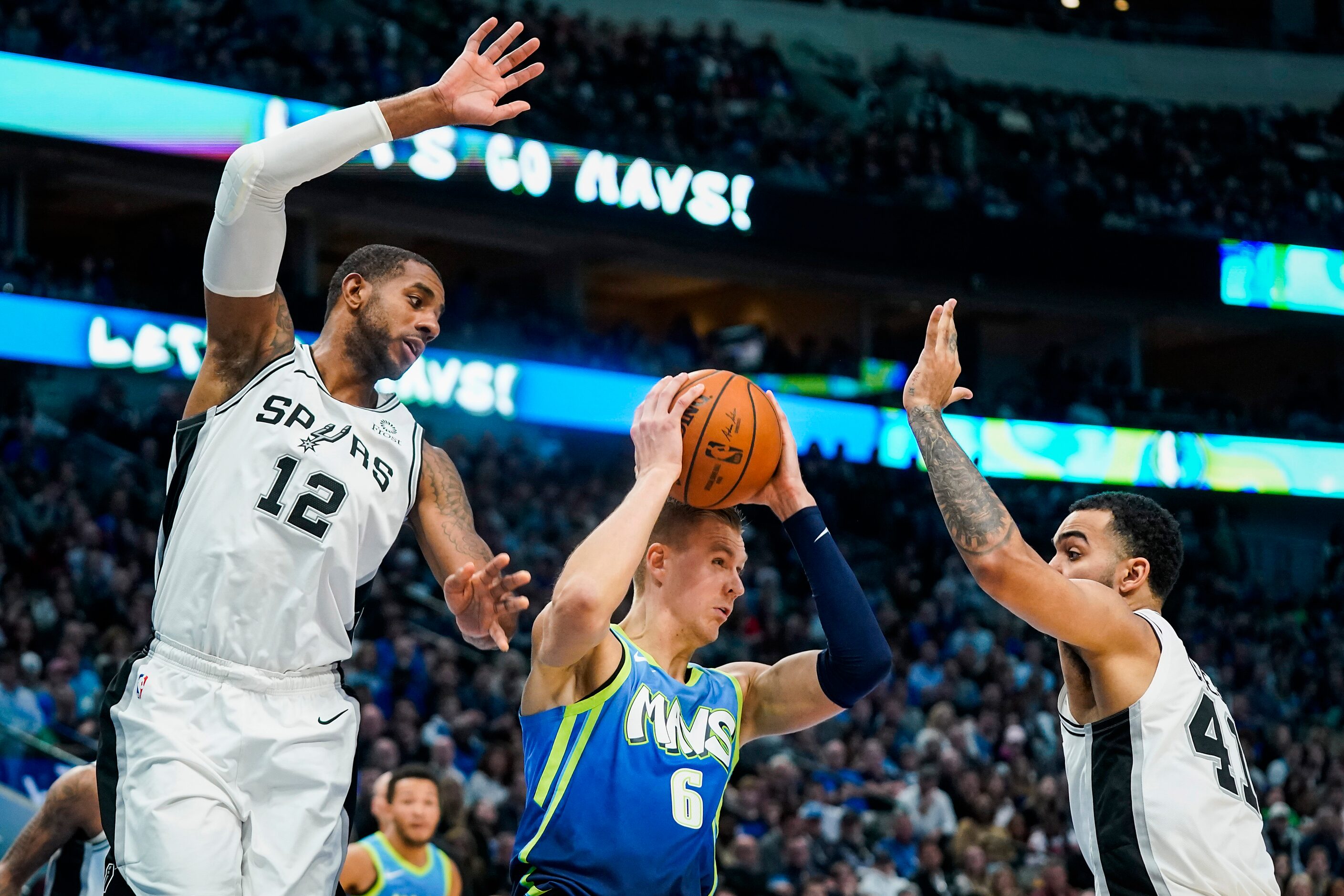 Dallas Mavericks forward Kristaps Porzingis (6) pulls down a rebound between San Antonio...