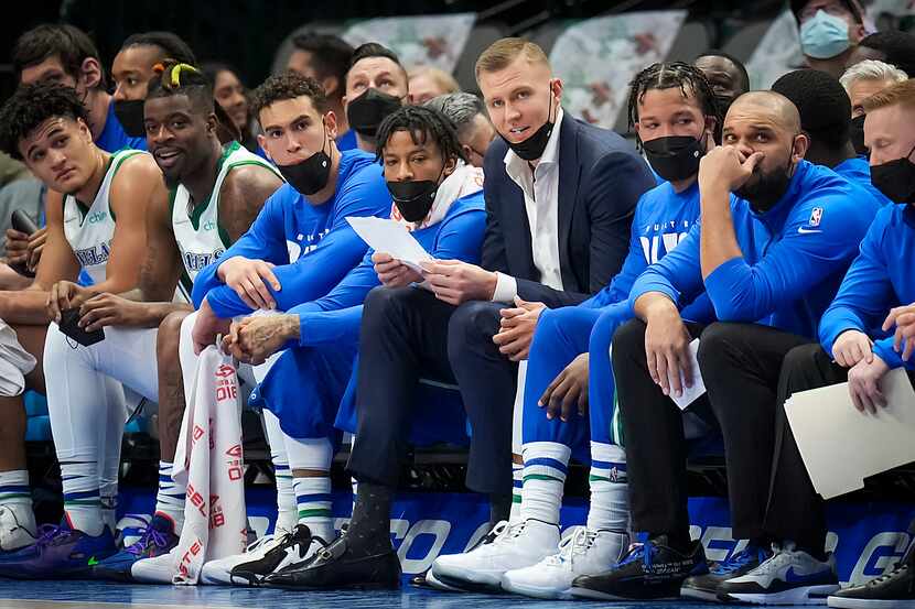 Dallas Mavericks center Kristaps Porzingis (center in street clothes) watches from the bench...