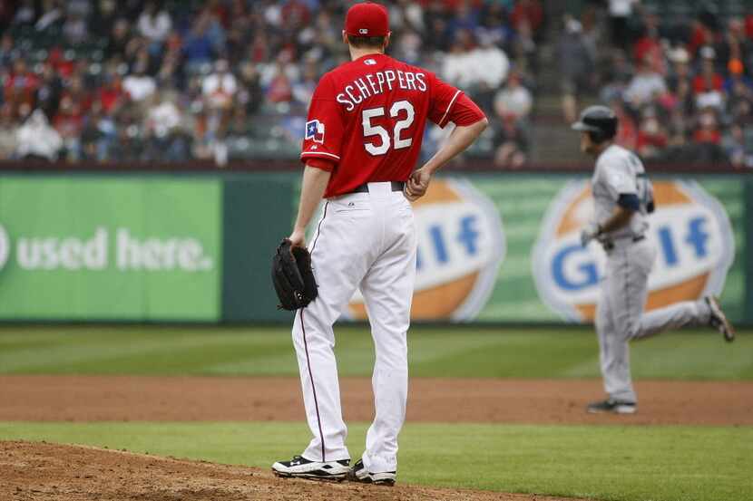 Texas Rangers pitcher Tanner Scheppers watches the Seattle Mariners' Corey Hart run out a...