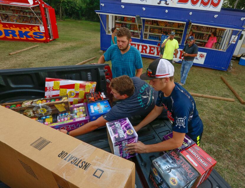 From left: Jeremiah Smith, Colton Taylor and Zane Taylor load up fireworks purchased by...