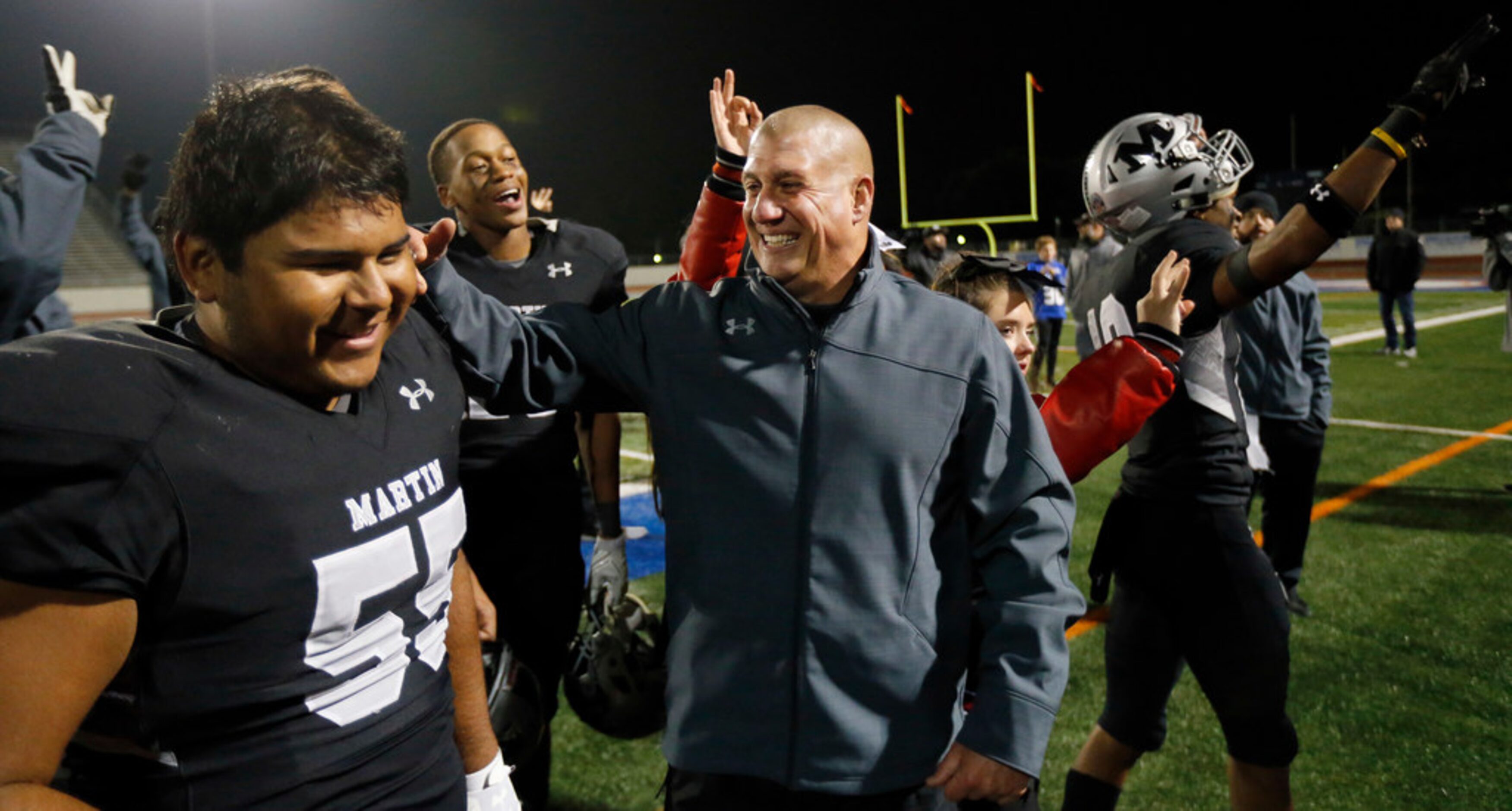 Martin head coach Bob Wager (center) congratulates his offensive lineman Carlos Rodriguez...