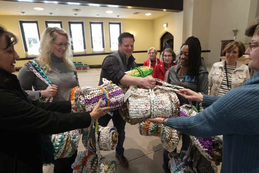 Members of CC Young Senior Living deliver crocheted mats made from plastic bags to members...