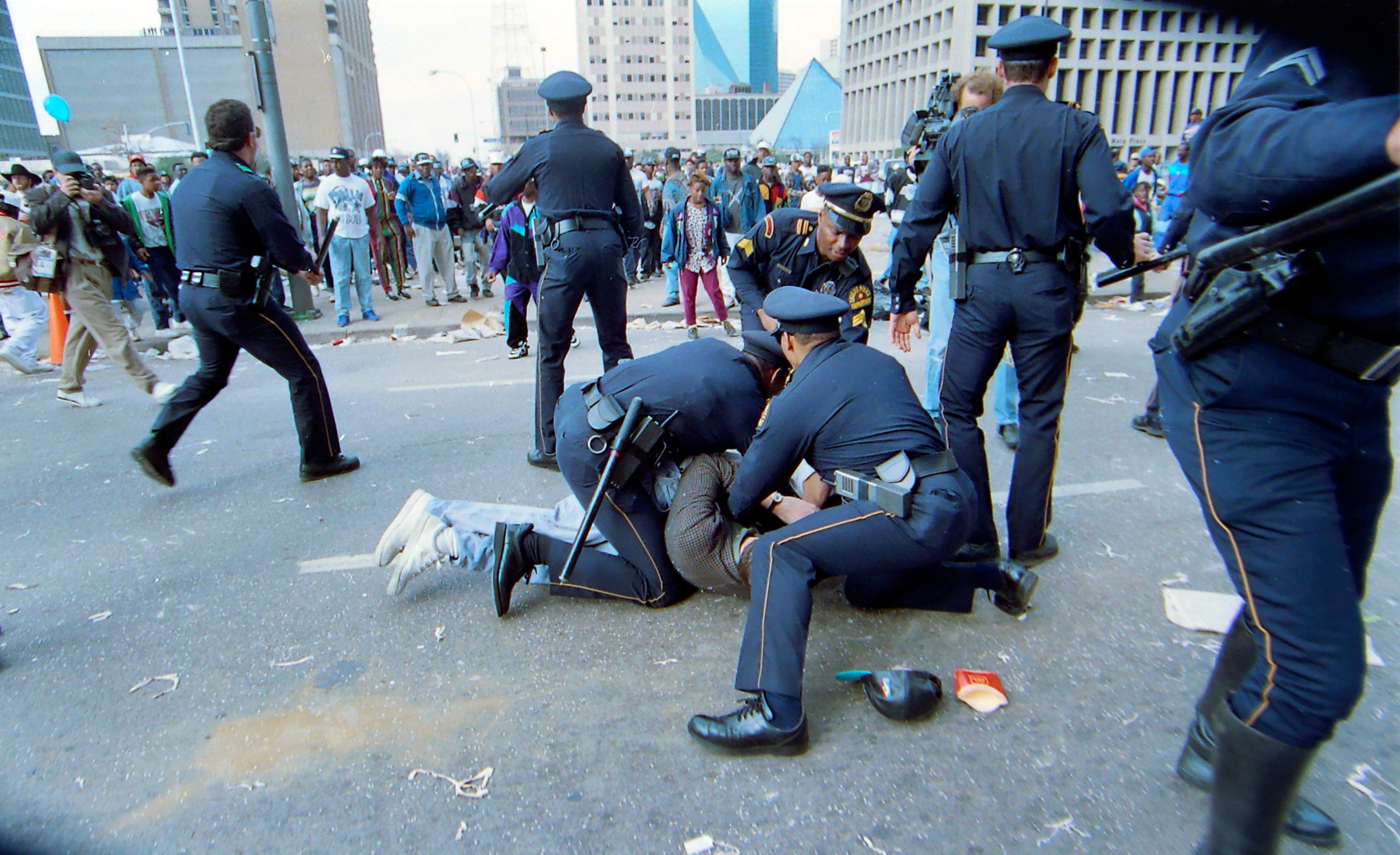 Dallas Police wrestle with a person who attacked a local television reporter following the...