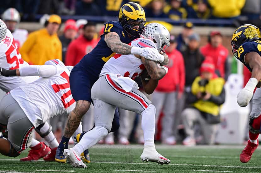 Ohio State running back TreVeyon Henderson was tackled by Michigan defensive end Braiden...
