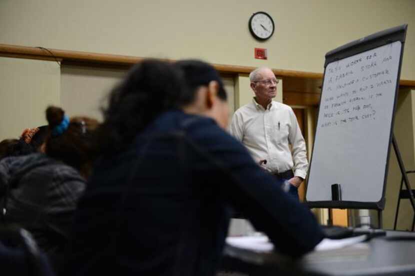 
Glenn Wakefield, a volunteer, teaches English to a group of intermediate ESL students at...