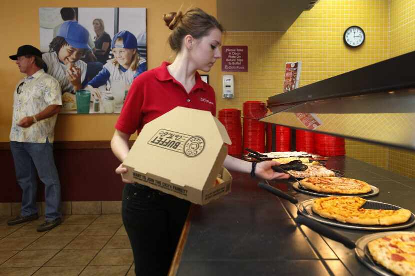 Shift Leader Lisa Festger fills a to go order at the CiCi's Pizza location on Coit in Plano,...