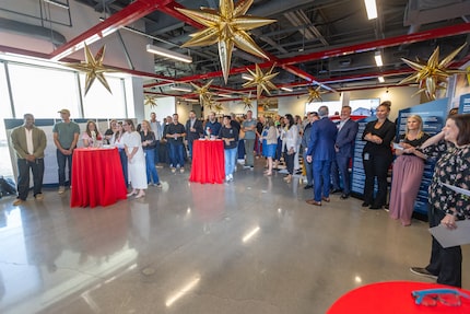 Inside a large open space modeled after a garage, dozens of people stand at an anniversary...