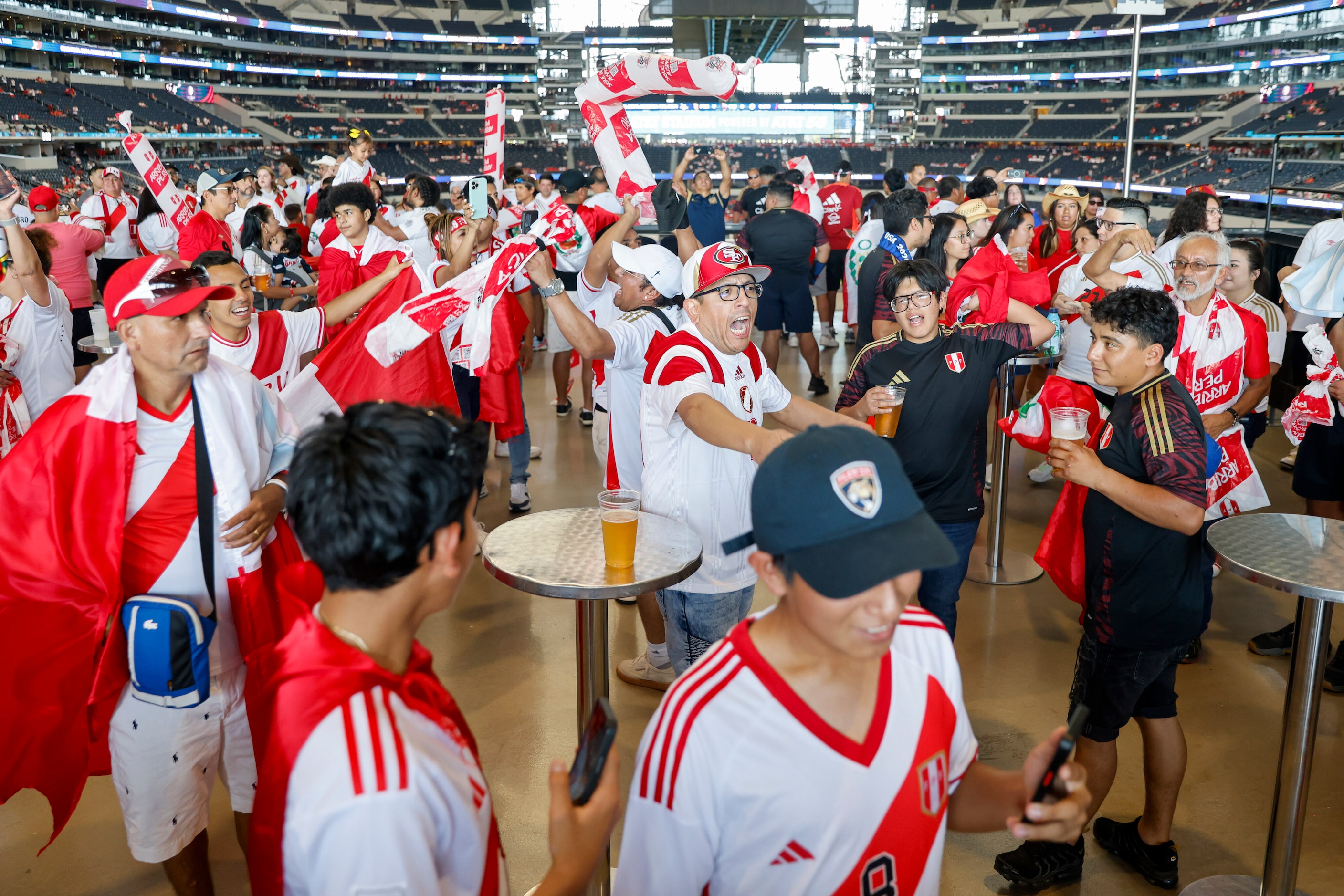 Peru soccer fans dance and sing on the concourse of AT&T Stadium before a Copa America Group...