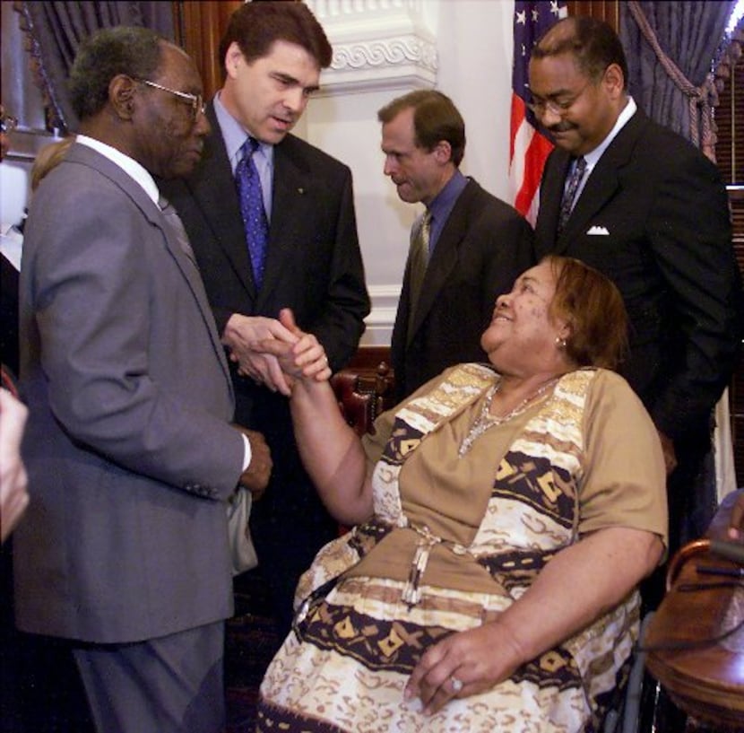 Then-Texas Gov. Rick Perry, second from left, shakes the hand of Stella Byrd, mother of...