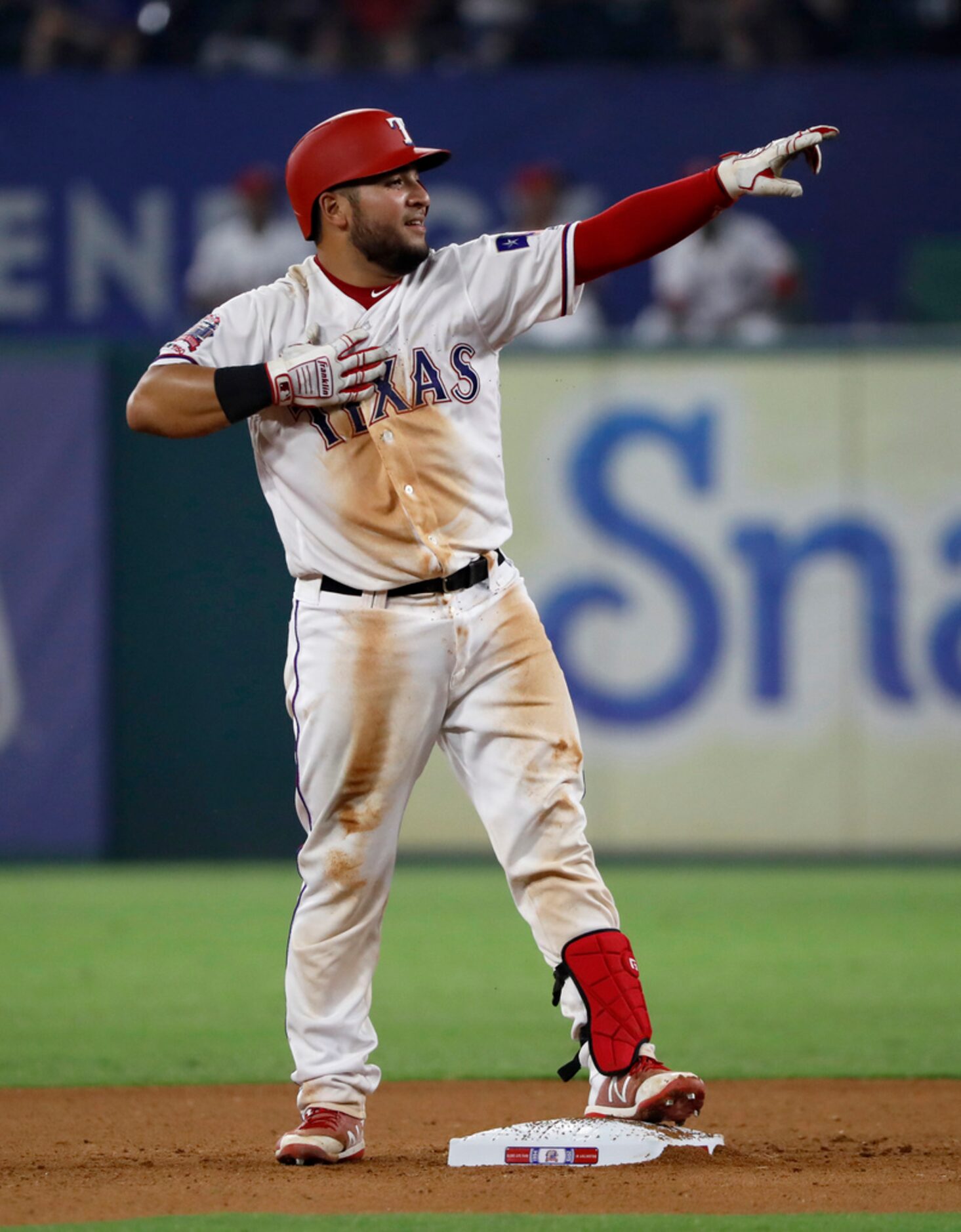 Texas Rangers' Jose Trevino gestures to the dugout celebrating after reaching second on an...