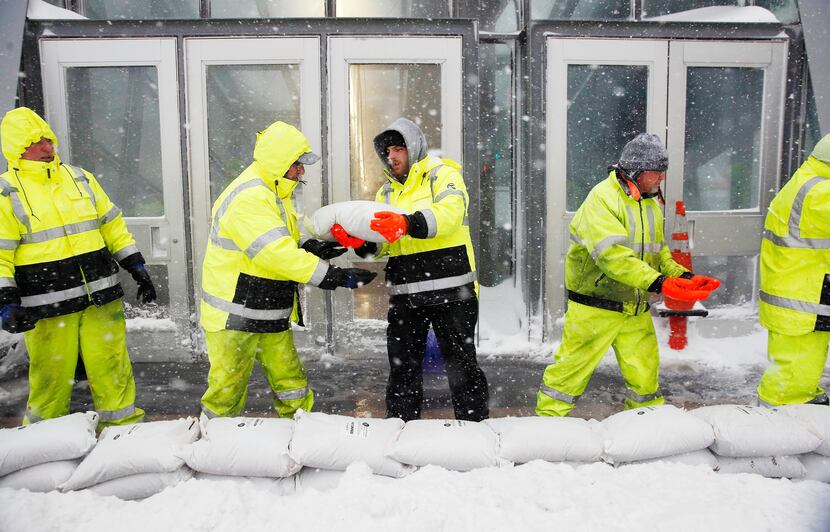 BOSTON, MA: Workers place sand bags in front of Aquarium subway station to protect against...