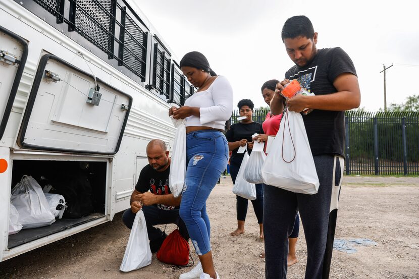 A group of migrants prepared to be transported to a detention center after crossing the Rio...