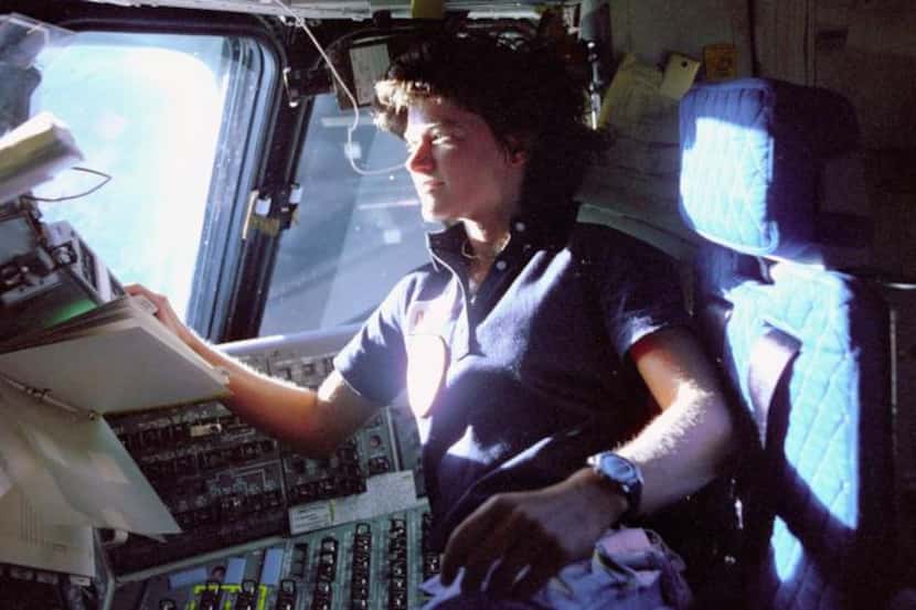 
Sally Ride monitors control panels from the pilot's chair on the flight deck aboard the...