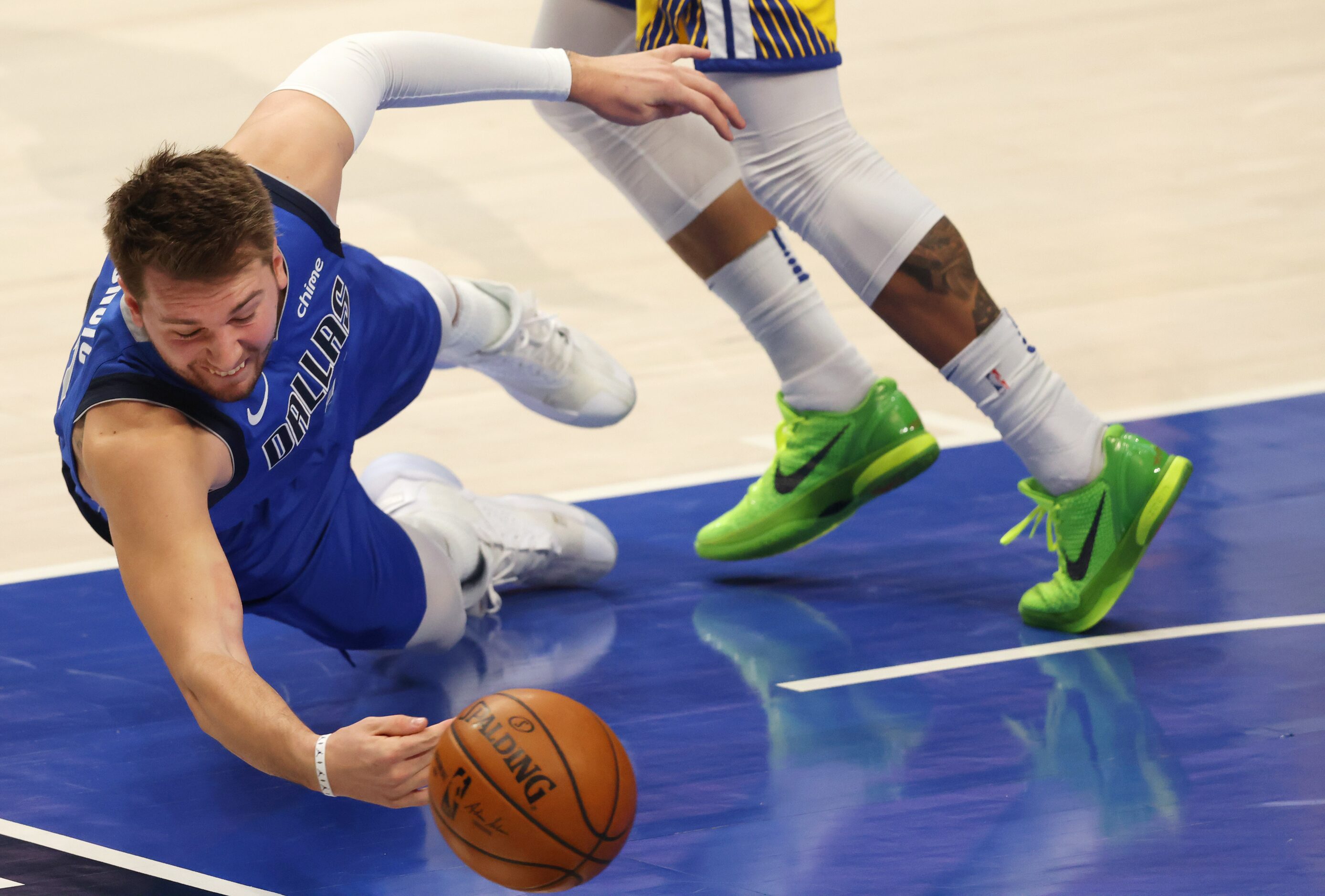 Dallas Mavericks guard Luka Doncic (77) dives for a loose ball that ended up going out of...