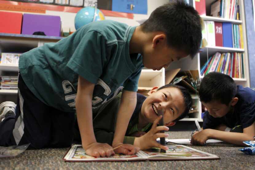 Third-graders (from left) Jason Huang, Alex Cheong and Ray Chu solve problems together in a...