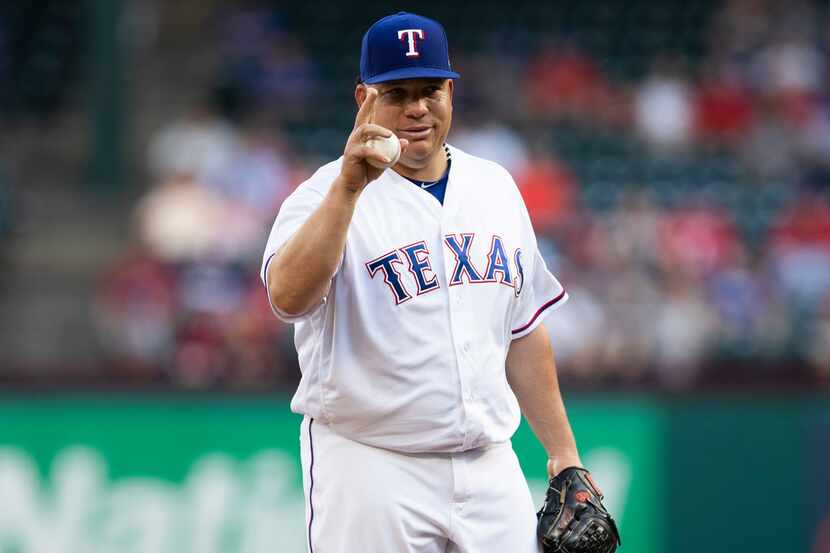 Texas Rangers starting pitcher Bartolo Colon acknowledges the Oakland Athletics bench before...