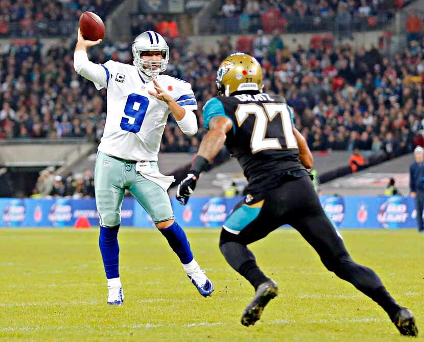 Dallas Cowboys quarterback Tony Romo (9) fires off a touchdown pass under pressure from...