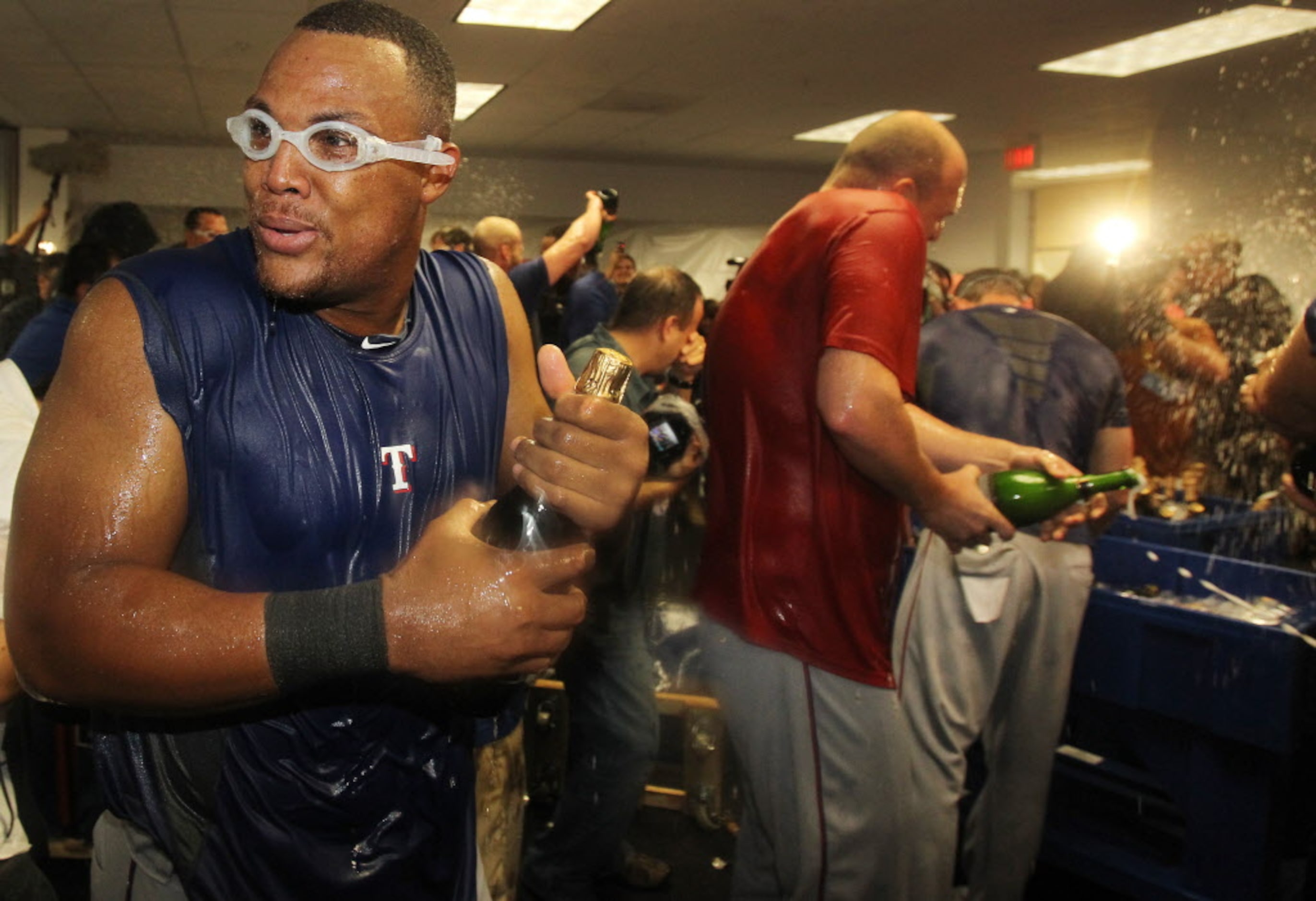 texas 3B Adrian Beltre celebrates with teammate Matt Harrison (in red) and others in the...