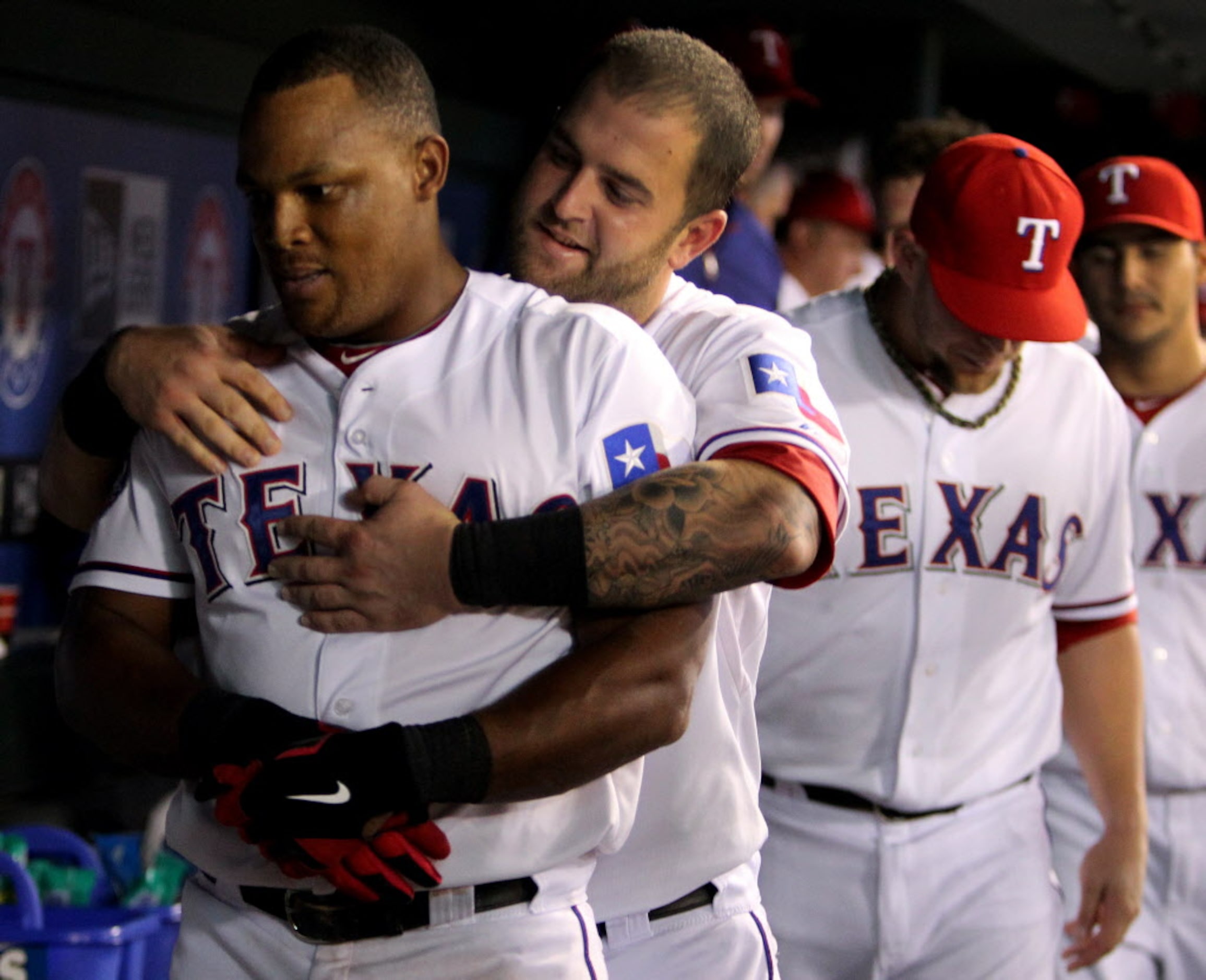 Texas' Adrian Beltre is hugged by catcher Mike Napoli in the dugout after Beltre's two-run...