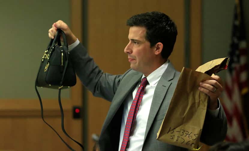 Defense attorney Cody Skipper holds up Anna Moses' purse that was found in the garage next...