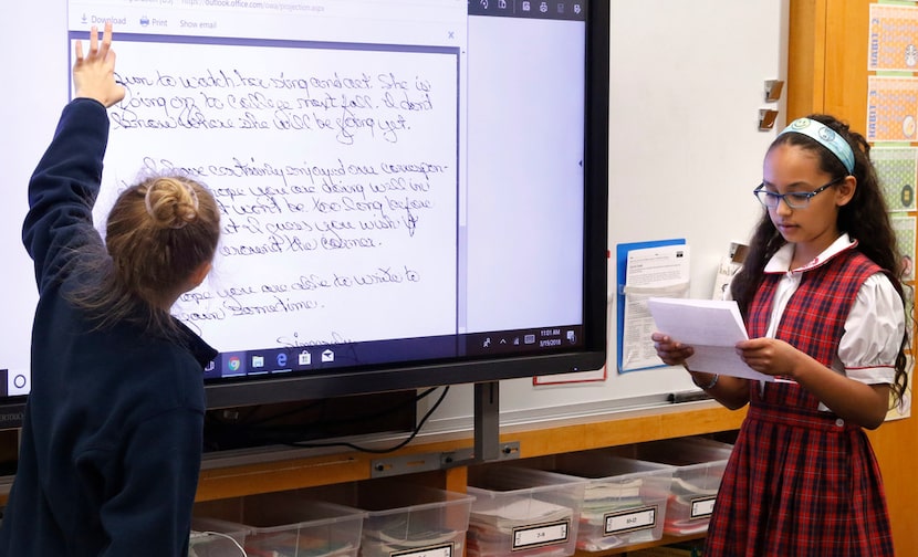 Olivia Tomaselli, 9, left, scrolls down the screen as Aliyah Cahill, 9, reads a letter from...