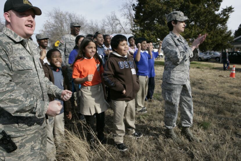 Students from nearby Sidney Lanier Elementary School and members of the Texas National Guard...