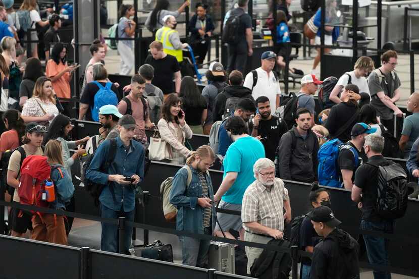 Travelers wait in long lines at a security checkpoint in Denver International Airport on...