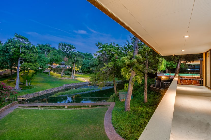 Side of midcentury modern house, view from balcony overlooking small neighborhood lake