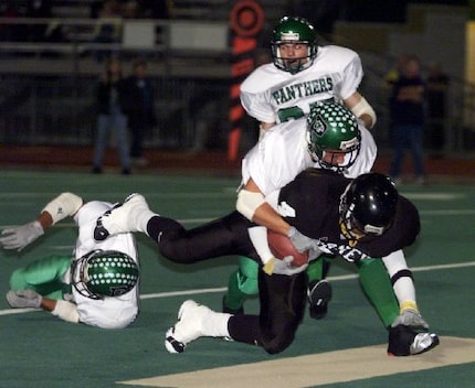 Forney's Bryson Brown (4) is taken down in the end zone by Mabank's Brandon Parker (2)...