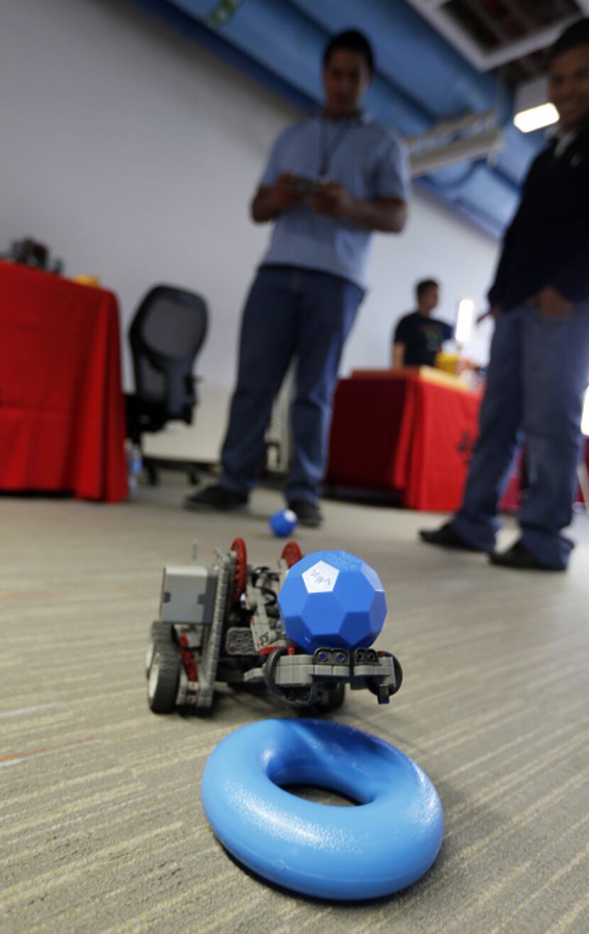 Juan Urtecho, an intern with Texas Instruments in Dallas, operates an iVEX, a robot made...