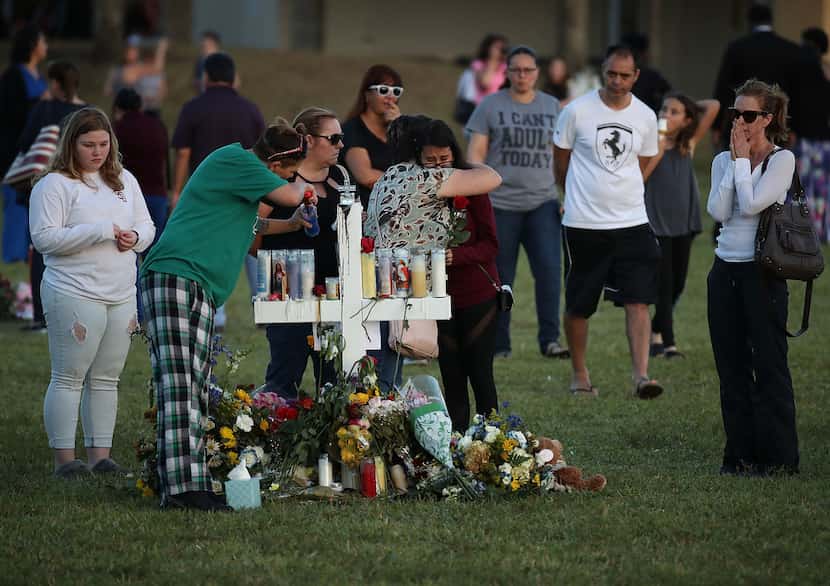 People visit a memorial at Pine Trails Park on Saturday in Parkland, Fla. Police have...