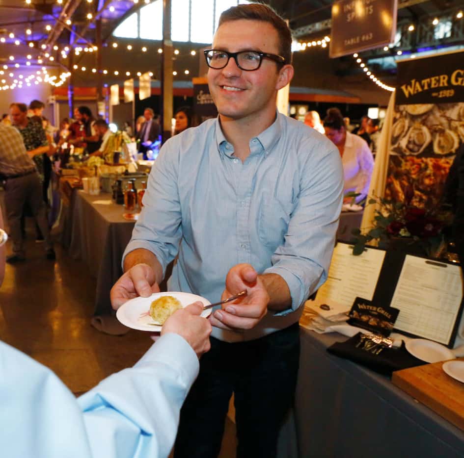 Water Grill's Cody Spencer, hands out crab cake with a celery root remoulade as fast as the...