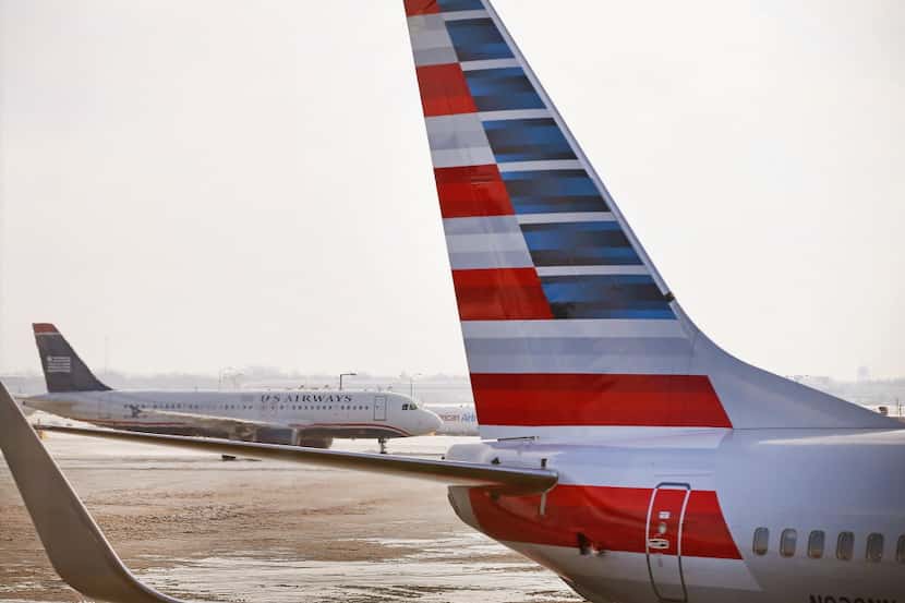 A US Airways jet passes an American Airlines craft at O'Hare Airport in Chicago.