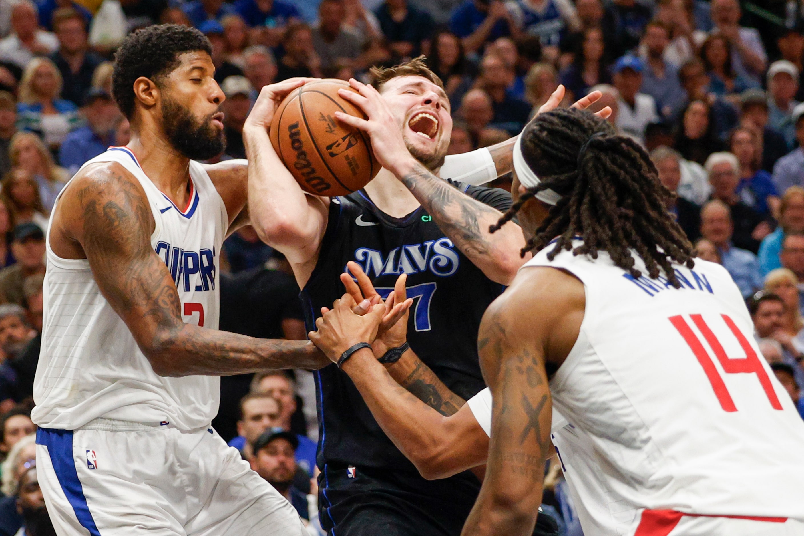 Dallas Mavericks guard Luka Doncic (77) collides with LA Clippers forward Paul George (13)...