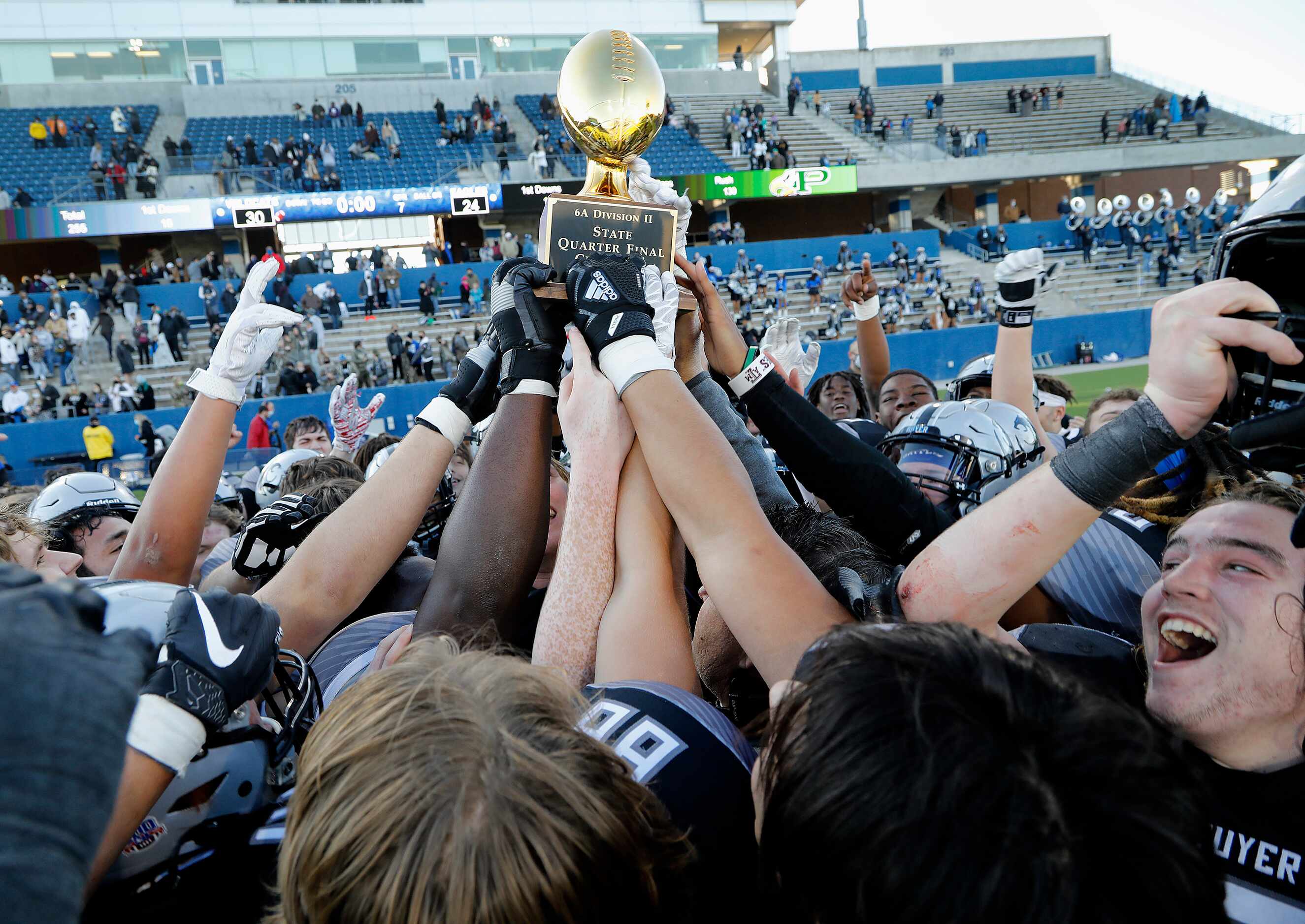 The Denton Guyer football team hoists their quarterfinal trophy after winning in three...