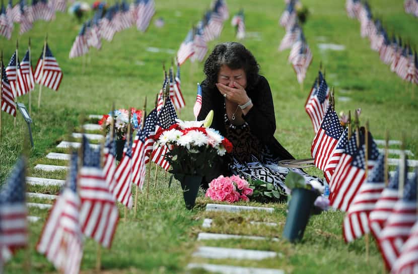 Una Pemberton of Wichita Falls weeps at the grave of her son, Clem J. Strait III, who served...