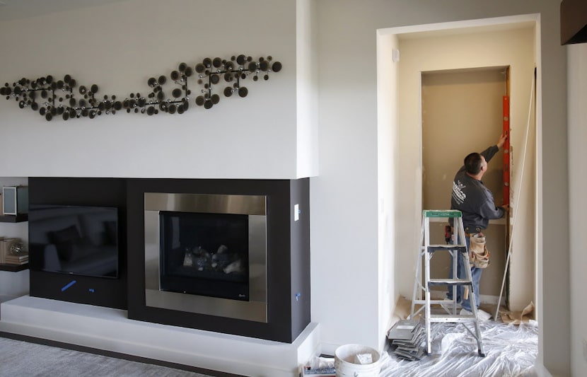 Jose Garcia of Dallas works on sheetrock inside a MainVue Homes Geneva Q1 model home at...