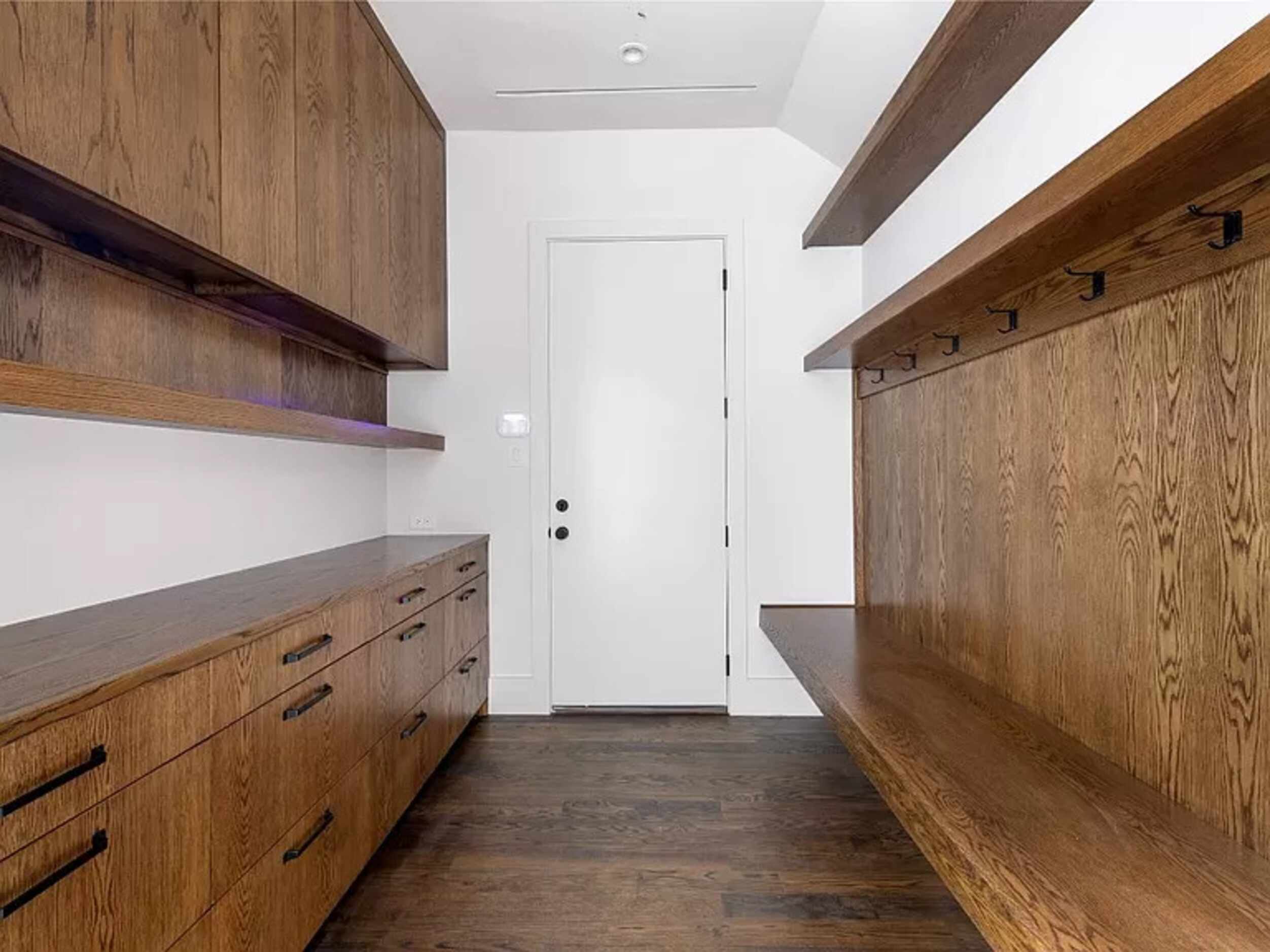 Interior utility room lined with shelves and hooks for coats.