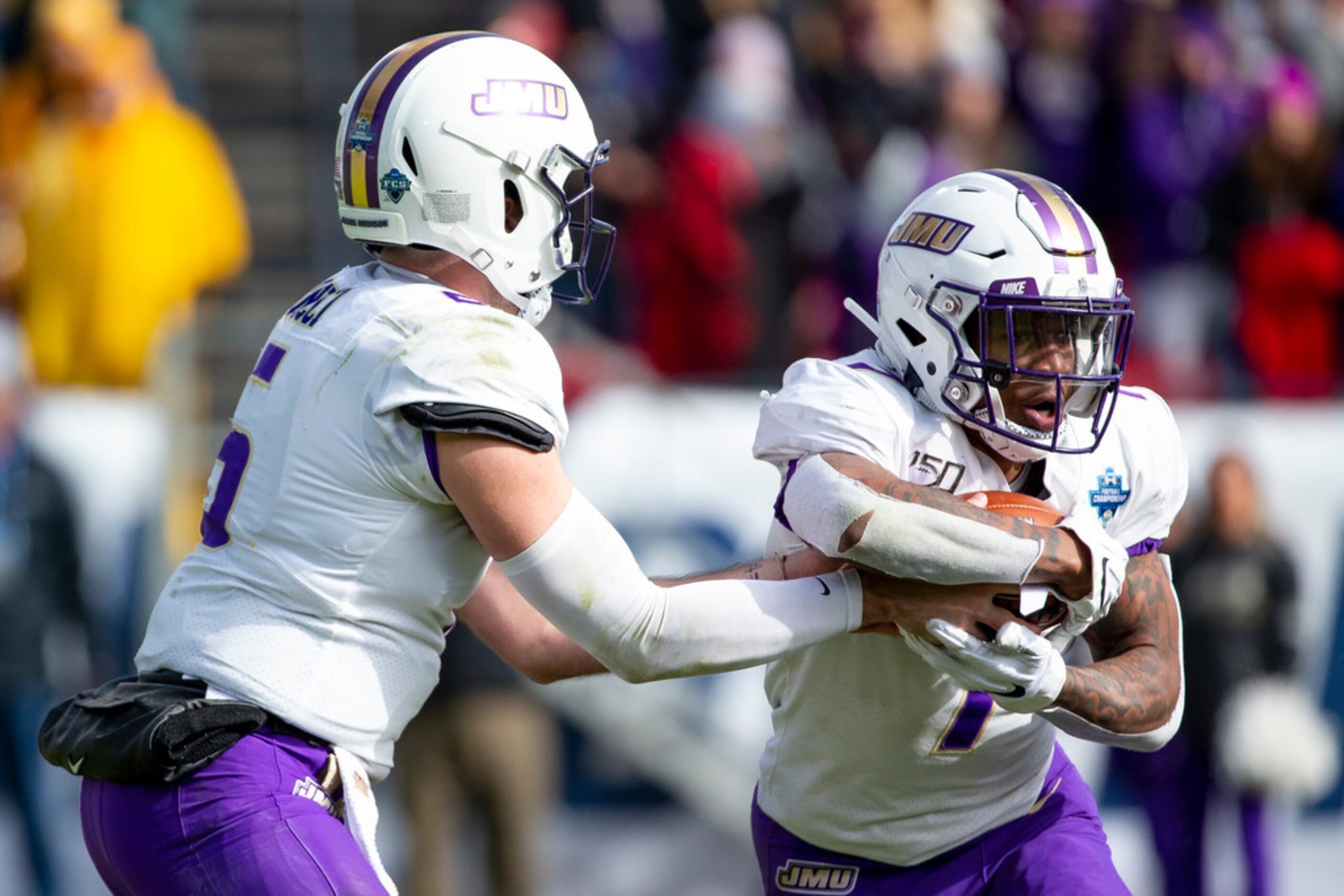 James Madison quarterback Ben DiNucci (6) hands the ball off to running back Jawon Hamilton...