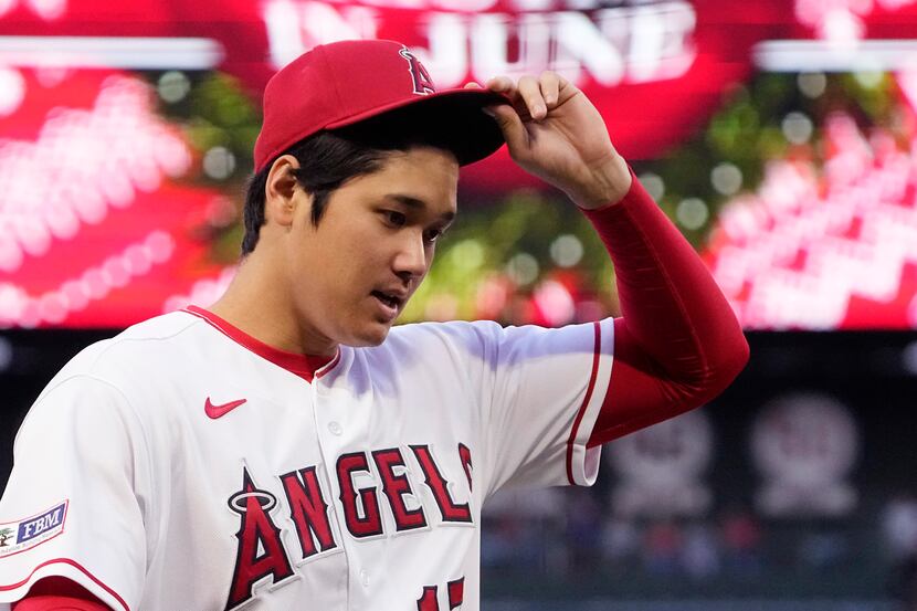 Los Angeles Angels' Shohei Ohtani tips his cap after warming up prior to a baseball game...
