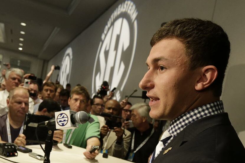 Texas A&M quarterback Johnny Manziel talks with reporters during the Southeastern Conference...