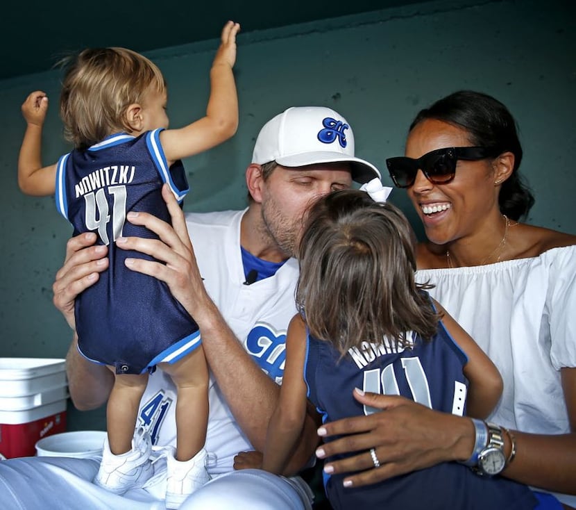 Mavericks Dirk Nowitzki kisses his 3-year-old daughter Malaika Nowitzki  as his wife Jessica...