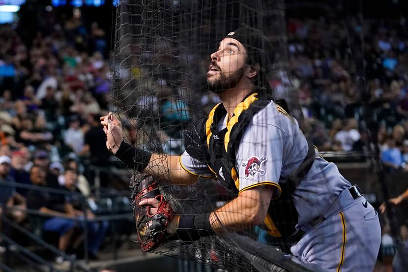 Pittsburgh Pirates catcher Austin Hedges runs out of room as he runs into the netting while...