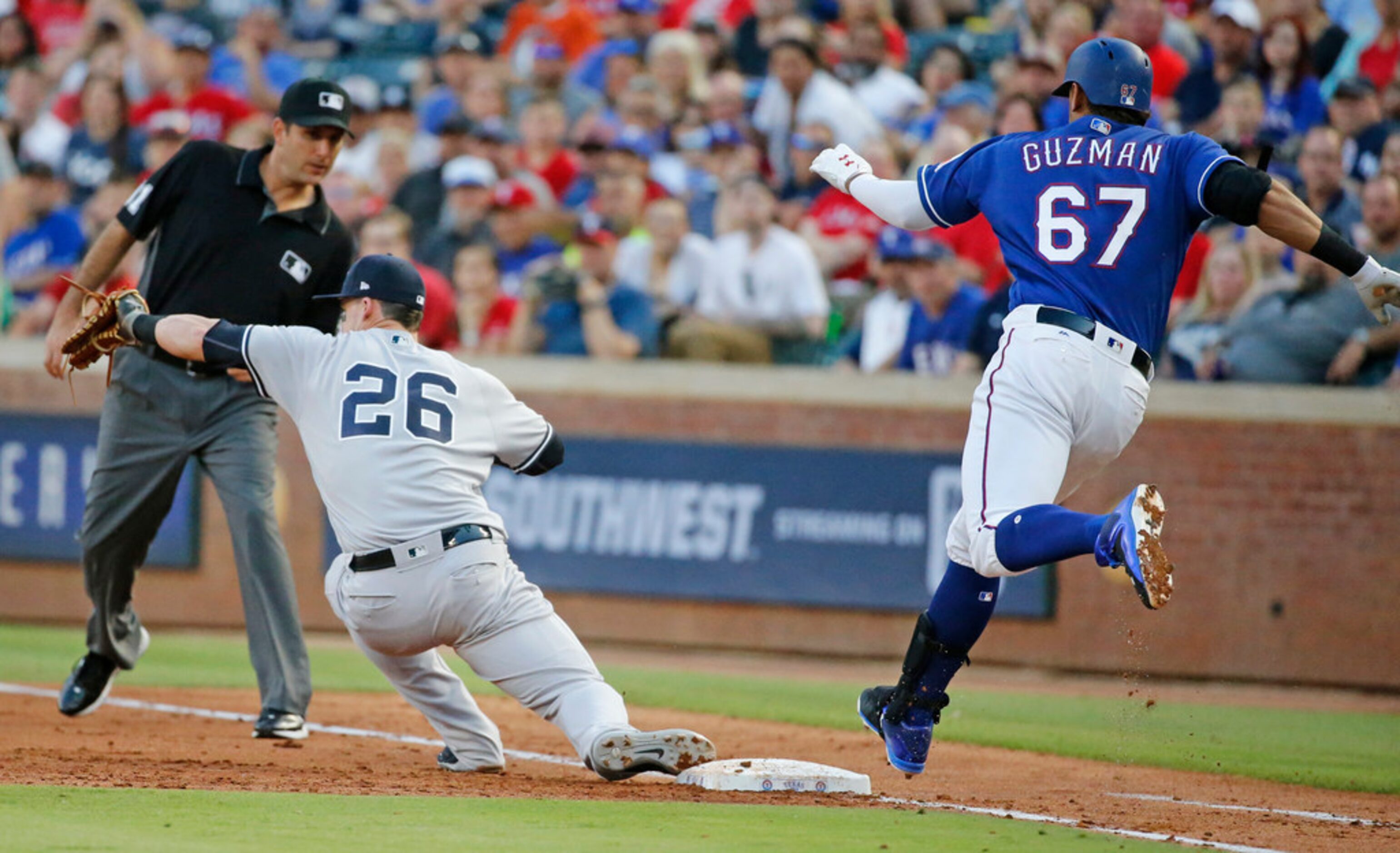 Texas Rangers first baseman Ronald Guzman (67) is out at first on a grounder in the second...